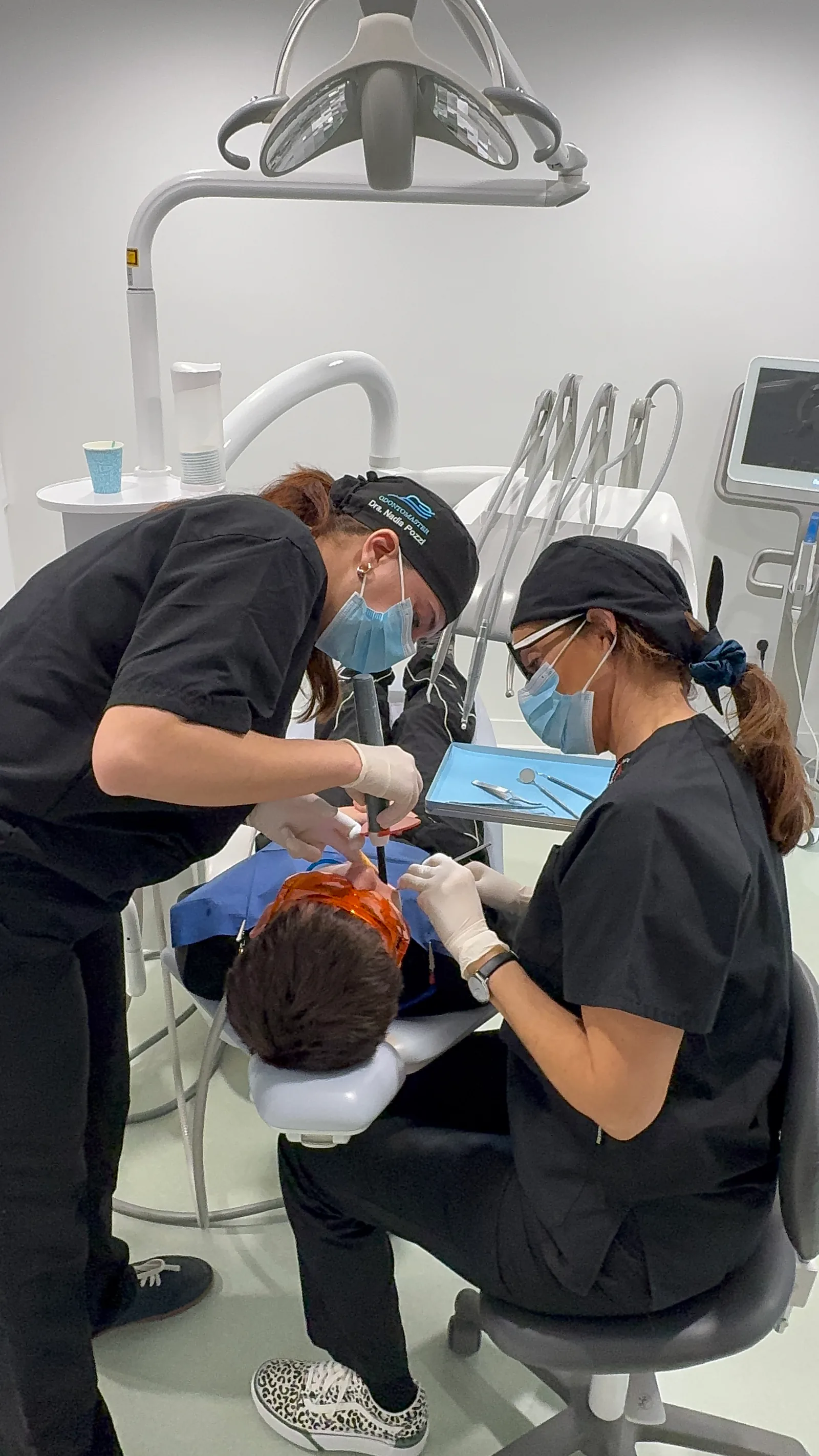 Alumnas de Odontomaster tratando a un paciente en clínica